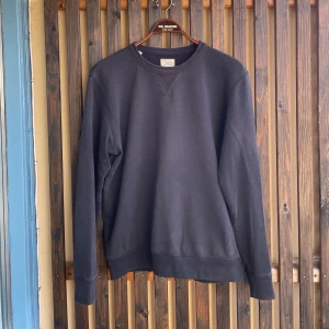 Mörkgrå sweatshirt från Selected Homme - En stilren solblekt svart sweatshirt från Selected Homme i rättare sagt M/L än XL som tröjan var vid köp. Tröjan har rund halsringning med ribbade muddar vid ärmslut och nederkant. Tillverkad i mjuk bomull, perfekt för en avslappnad look. Två små hål visas på bild. 