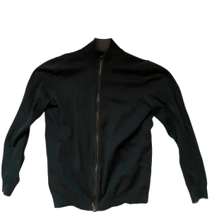 Grön kofta med dragkedja från Massimo dutti  - Grön kofta med hel dragkedja framtill och ribbad krage. Tröjan har långärmad design och är tillverkad i ett mjukt material som passar perfekt för kyliga dagar. Enkel och stilren look som funkar till många olika outfits.