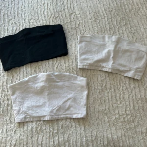 3-pack bandeau tubtoppar 157 XS/S - Säljer tre bandeau tubtoppar från 157 i storlek XS/S. Två är vita och en är svart, alla i mjuk bomull med stretch. Perfekta att styla under skjortor eller till höga jeans. Enkel och clean design utan mönster eller detaljer.