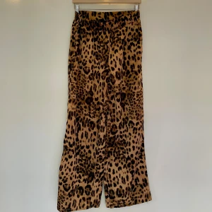 Leopardmönstrade vida byxor - Snygga vida byxor med leopardmönster i bruna och svarta toner. Skönt satin - material 
