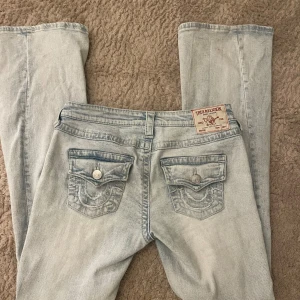 True Religion jeans - Låg midjade jeans i storlek W25. Använda fåtal gånger och har hål runt midjan (se bild) då jag har haft ett snöre där för att försöka göra midjan mindre.