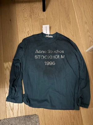 Acne studios tröja  - Långärmad T-shirt från acne studios i en grön blå färg avgör själv. Mycket bra skick sitter oversized och är i storlek L. Vid frågor skriv och kom gärna med bud 