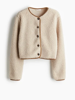 Beige teddyjacka med bruna detaljer - Mysig beige teddyjacka med rund halsringning och bruna kantband. Jackan har knäppning framtill med mörka knappar och en croppad passform. Perfekt för dig som gillar en avslappnad och trendig stil. Tillverkad i mjukt teddy-material som håller dig varm. Slutsåld överallt!!! Nypris är 350kr! Helt som ny!