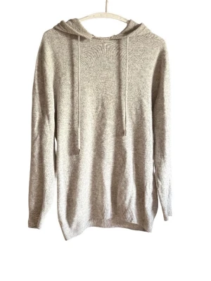 Ljusgrå stickad kashmir hoodie - Mysig ljusgrå stickad hoodie med huva och dragsko. Tröjan har långa ärmar och ribbade muddar vid ärmslut och nederkant. Perfekt för lager på lager och chill dagar. Materialet ser ut att vara mjukt och bekvämt.