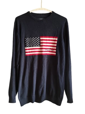 Mörkblå stickad tröja - Mörkblå stickad tröja  med amerikansk flagga broderad på bröstet. Tröjan har rund halsringning och långa ärmar. Perfekt för dig som gillar klassisk och stilren design med en touch av USA.