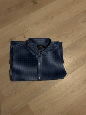 Blå Rutig Ralph Lauren Skjorta Storlek XXL - Klassisk Ralph Lauren skjorta i blå färg. Tröjan är i mycket bra skick, sparsamt använd. |  Storlek: XXL | Skick: mycket bra skick! | Färg: Blå | Märke: Ralph Lauren | Modell: Skjorta   |  Hör gärna av dig vid frågor så svarar jag så fort jag kan! 😁|  