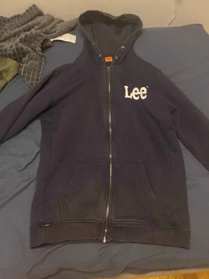 Mörkblå hoodie med dragkedja från Lee - Snygg Lee zip up tröja/ hoodie i färgen mörkblå. Köpt för 200kr säljer för att jag behöver pengar och vill bli av med gamla kläder.