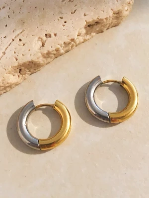 Örhängen i Stål med 18K Pvd Guld, Silver Stål, Vattentålig - THEODORA - Vattentåliga Stål Örhängen Dessa eleganta örhängen tillverkade i rostfritt stål med 18K PVD-guldplätering & högpolerad finish direkt på stålets originalfärg – de är både stilrena och slitstarka. Smycket är hypoallergent och vattentåligt – perfekt för daglig användning, även i dusch, träning eller på resa och är lämpliga även för känslig hud.  Material: Rostfritt stål Plätering: 18K PVD Guldplätering & Högpolerad finish direkt på stålets originalfärg Vikt: 8-9 g