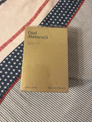 Oud Maracujá Maison Crivelli parfym - Lyxig parfym från Maison Crivelli, Oud Maracujá, i en elegant guldfärgad förpackning. Flaskan innehåller 100 ml och doften är en unik kombination av oud och maracuja. Perfekt för dig som gillar exklusiva och djupa doftnoter.