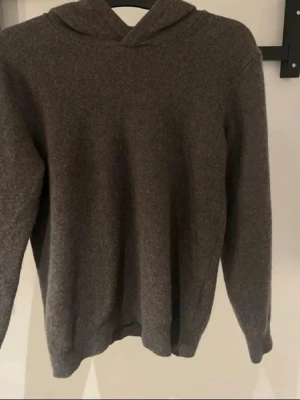 Kashmir hoodie - Mysig brun stickad hoodie från Vailent i mjuk merinoull. Tröjan har huva, långa ärmar och ribbade muddar vid ärmslut och nederkant. Perfekt för dig som gillar en enkel och stilren look med extra komfort.