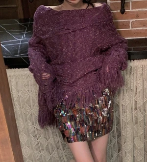 Oversized lila stickad tröja med fransar - Säljer en oversized stickad tröja i lila med grovt kabelstickat mönster. Tröjan har offshoulder-skärning, långa ärmar och coola slitna detaljer samt fransar längs nederkanten och ärmsluten. Perfekt för dig som gillar statement-plagg och unik stil.