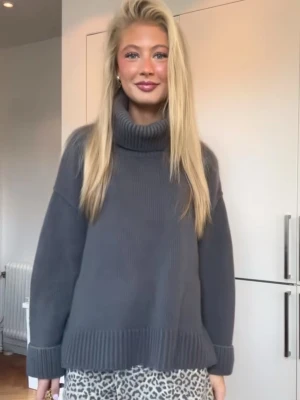 Mörkgrå stickad polotröja - Mysig mörkgrå stickad polotröja med oversized passform och bred ribbad kant vid ärmslut och nederkant. Polokragen är rejält hög och ger en riktigt chill vibe. Perfekt för kalla dagar när du vill vara både bekväm och snygg. Storlek L men jag har S/M och passar perfekt!