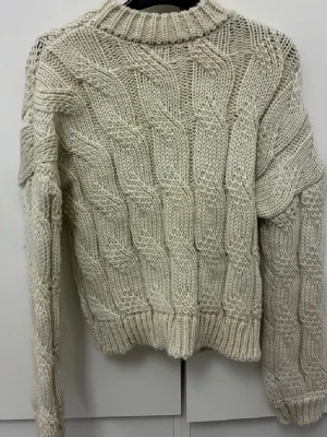 Beige stickad tröja från NA-KD - Säljer en chunky beige stickad tröja från NA-KD med grovt flätmönster och ribbad krage, ärmslut och nederkant. Tröjan har lång ärm och en loose passform som ger en chill vibe. Perfekt för att hålla sig varm under kyliga dagar.