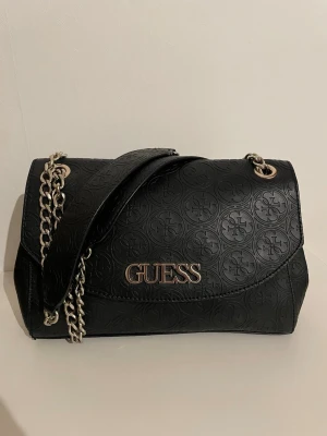 Svart axelväska från Guess - Säljer denna snygga svarta axelväskan från Guess ( äkta ) 💕 Stilren och modern design, precis som ny! 