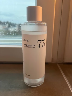Anua Heartleaf 77% Soothing Toner - Fräsch och återfuktande toner från Anua med 77% heartleaf-extrakt. Kommer i en genomskinlig plastflaska med vit etikett och lock, 250 ml. Perfekt för dig som vill ha en lugnande och lätt ansiktsvård i din rutin.