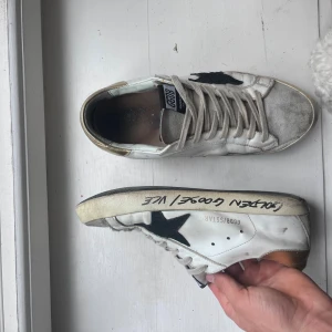 Guldiga Golden goose superstar  - Säljer ett par guldiga golden goose superstar! Hur snygga som helst och bekväma eftersom att dem är en bredare sko. Jag lämnade precis in dem på lagning för att fixa hälen som var sprucken! Även fixade jag en uppfräschning på dem. Så nu är dem i allra bästa skick! Hör av e vid funderingar