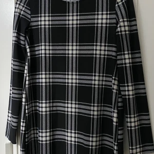 Svartvit rutig klänning från Mango - En jättefin rutig klänning med inga skada eller fläckar som ni ser i bilden! Jag tycker att det kan vara för både barn och dam. Måttet är att länden är 86cm och bredden (från ena axeln till den andra) är 39cm. Meddela mig gärna för mer info! 💕💕