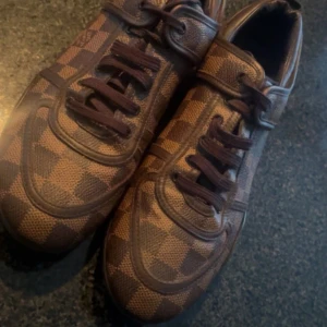 LV Trainer sneaker från Louis Vuitton - Säljer ett par exklusiva Louis Vuitton-sneakers, modellen LV Trainer, kända för sin lyxiga design och ikoniska Monogram-/Damier-detaljer. Storlek 38 I mycket fint skick både stilrena och bekväma  📦 Observera: Originalkartong och kvitto följer ej med, då skorna var en gåva från Vestiaire   Pris kan diskuteras vid intresse