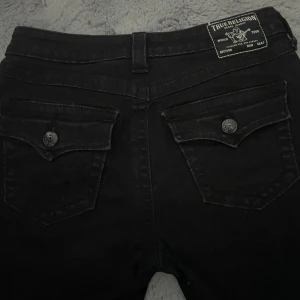 Svarta jeans från True Religion - Säljer ett par svarta jeans från True Religion, modell Becca. Storlek 29. Fina jeans men lite slitna längst ner. Säljer för att dom inte passar mig🩷