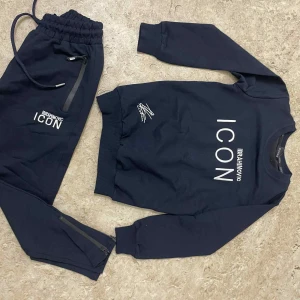 Svart sweatshirt DSQUARED2 ICON - Cool svart sweatshirt från DSQUARED2 med stort grafiskt tryck på ryggen och texten 'ICON IBRAHIMOVIC' framtill. Tröjan har rund hals, långa ärmar och ribbade muddar. Perfekt för dig som gillar streetstyle och statement-plagg.