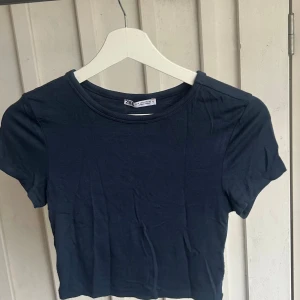 Marinblå T-shirt från Zara - Supermjuk och skön basic T-shirt från Zara i marinblå. Ganska kort modell.