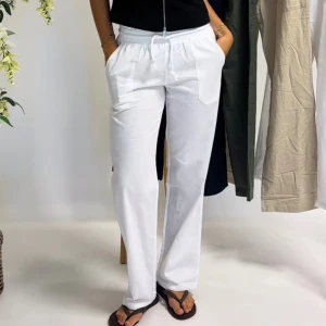 Vita linnebyxor från Skagen Clothing - Snygga vita linnebyxor från Skagen Clothing i storlek XXS. Byxorna har rak passform, elastisk midja med snörning och stora fickor framtill. Knappt använda. Nypris 899 kr