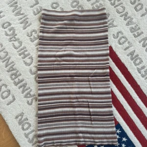 Randig ribbad kjol från Vila - Säljer en ribbad kjol från Vila i storlek M med horisontella ränder i brunt, beige och vitt. Kjolen är figurnära och har en kort längd, perfekt för dig som gillar en enkel men snygg look. Materialet är mjukt och stretchigt för skön passform.