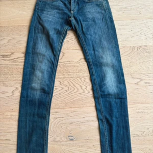 Dondup w28 - Snygga blå jeans med skinny fit och klassisk femficksdesign. Jeansen har en normal midja och är tillverkade i mjukt denimtyg med lätt slitning på låren. Perfekta för dig som gillar en smal siluett och stilrena detaljer.