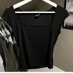 Svart topp med fyrkantig ringning - Kortärmad mjuk topp med fyrkantig ringning