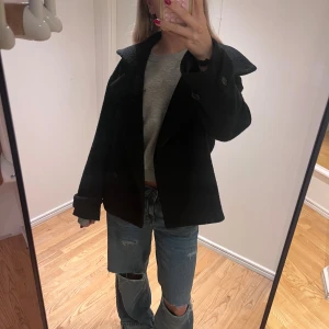 Svart ullkappa från ARKET - Svart ullkappa från ARKET med krage och knappar framtill. Jackan är tillverkad i ull från Manteco. Har ett hål i innefodret som varken syns eller känns. Nypris ca 3000kr, pris kan alltid diskuteras!