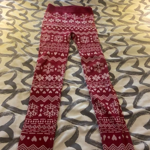 Röd jultröja med snöflingor och hjärtan - Röd stickad jultröja med vita snöflingor, hjärtan och klassiska vintermönster. Tröjan har lång ärm och rund halsringning, perfekt för att maxa julkänslan. Mjuk och skön att ha på sig under kalla dagar.