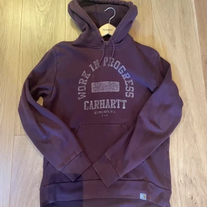 Vinröd Carhartt hoodie med tryck - Skön carhartt hoodie, trycket är distressed 