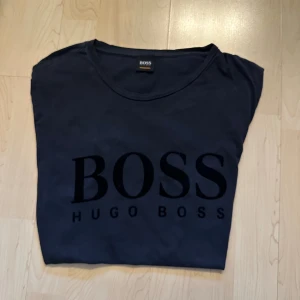 Hugo Boss t-shirt svart - Svart t-shirt med trycket "BOSS HUGO BOSS" framtill. Klassisk modell med rund hals.
