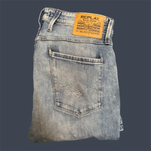 Replay Anbass - Säljer ett par ljusblå jeans från Replay med klassisk femficksdesign och snygga slitningar. Jeansen är modellen anbass och sitter riktigt nice! Storleken är W33 | L32