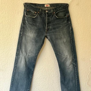 Blåa Levi’s - 501 - Snygga blåa Levi’s med snygg slitning! Byxorna har ett lagat hål på knät som man kan sprätta upp om man vill ha hålet, och slitningar i hälarna. De två första bilderna var för stora för plick, därav ser man inte hela byxan!