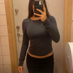 Gina Tricot Kall Mörkgrå soft touch topp - Snygg mörkgrå långärmad tröja från Gina Tricot med tight passform. Enkel och stilren design som sitter nära kroppen och har rund halsringning💞