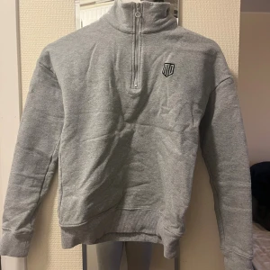 Maya Delores heather halfzip - Snygg grå tröja från Maya Delorez med halv dragkedja och hög krage. Tröjan har broderad logga framtill och stor text på ryggen. Mjuk och skön, perfekt för lager-på-lager. Långärmad och ribbade muddar för extra komfort. Tröjan är knappt använd och tror inte den säljs numera på maya Delores hemsida därför har jag satt nästan det priset det köptes för fast fortfarande billigare än nypris såklart. 😊