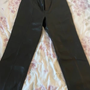Skinnbyxor straight  - Svarta skinnbyxor från Lindex i storlek 36. Byxorna har raka ben och klassisk passform med knapp och dragkedja framtill. Snyggt stilrena och perfekta för att lyfta vilken outfit som helst. Säljer pga ingen använding och inte min storlek.