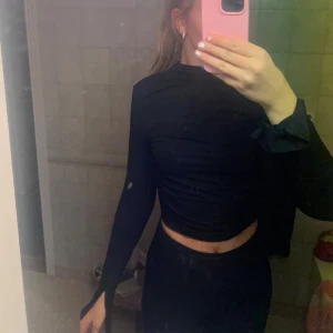 Svart croppad långärmad topp - Säljer en svart croppad topp med långa ärmar och hög hals. Toppen har en tight passform och är tillverkad i ett stretchigt material som sitter snyggt på kroppen. Endast använd en gång så i nyty skick☺️