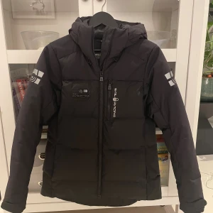 Sail Racing M Cape Down Jacket (Ny pris 4 199kr) - Egentligen herrjacka men jag använde den ändå 😊 Använd ytterst få gånger! Jätteskön, varm och vind- och vattentät!                              Dunjacka Herrstorlekar; M 70% dun och 30% fjäder (500 fillpower) Vind- och vattenavvisande yttertyg Elastisk innermudd i ärmsluten Justerbar dragsko i nederkant Reflekterande detaljer Vattenavvisande DWR-impregnering Länk: https://www.stadium.se/herr/herrklader/jackor/dunjackor/353773101/sail-racing.m-cape-down-jacket.carbon