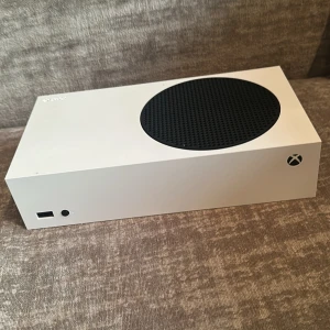 Xbox Series S - Xbox Series S i vitt med två trådlösa handkontroller. Konsolen och kontrollerna är i gott skick med mindre tecken på normalt slitage. Perfekt för gaming med snabb prestanda och kompakt design. Allt fungerar som det ska och är redo att användas direkt.