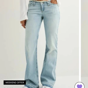 Ljusblå bootcut jeans från Nelly - Säljer ett par ljusblå jeans från Nelly med låg midja och bootcut. De har slitningar i midjan och nere vid fötterna💞super fina byxor som passar till allt🥰