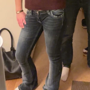 Blå bootcut jeans  - Säljer ett par blå bootcut jeans med låg midja och snygga broderade detaljer på bakfickorna. Jeansen har ljusare slitningar och är tillverkade i stretchigt denim för skön passform. Jenssen kommer tyvärr inte till användning och säljer därför🩷enbart använda 3 gånger🫰🏼