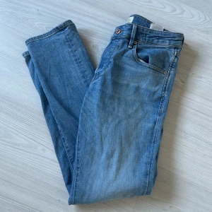 Blå jeans från Jack & Jones, 30/32 - Säljer ett par klassiska blå jeans från Jack & Jones i storlek 30/32. Jeansen har fem fickor, normal passform och är tillverkade i mjukt denimtyg. Perfekta för dig som gillar en tidlös och avslappnad look.