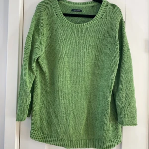 Grön stickad tröja Marc O'Polo XL - Snygg grön stickad tröja från Marc O'Polo i storlek XL. Tröjan har rund halsringning, ribbade muddar och lång ärm. Materialet är mjuk bomull och den har en metallbricka med logga vid nederkanten. Perfekt för dig som gillar chill och enkel stil. Mått Över bröstet: ca 66 cm Längd från axeln och ner: ca 70 cm  76% bomull och 24% polyamid  Kommer från ett djur och rökfritt hem.