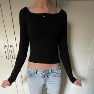 Svart långärmad topp från Kappahl - Säljer en svart långärmad topp från Kappahl i storlek 146/152. Modellen är slim och croppad med en enkel, stilren design och rundad halsringning. Perfekt att matcha med jeans eller kjol för en clean look.