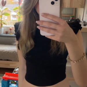 Svart topp från Zara  - Jätte snygg och stilren topp med volanger från Zara passar perfekt till jeans eller kostymbyxor.