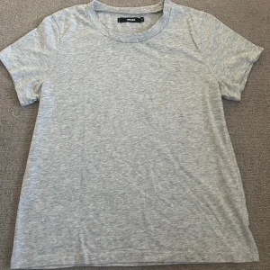 Grå basic t-shirt från Bik Bok - Enkel och stilren grå t-shirt från Bik Bok i mjuk bomull. Klassisk rund halsringning och korta ärmar. 