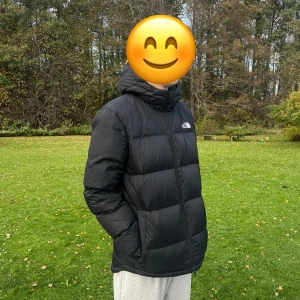 Svart dunjacka från The North Face M - Säljer en svart dunjacka från The North Face i storlek M. Jackan har en puffig look, huva och dragkedja framtill. Perfekt för kalla dagar och har logga både fram och bak. Jackan är i klassisk svart färg och har en clean, sportig vibe.