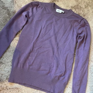 Lila tröja  - Superfin lila tröja från Saint Tropez i storlek XS. Tröjan har rund halsringning, långa ärmar och bred ribbad mudd vid ärmslut och nederkant. Perfekt att styla med jeans eller kjol för en snygg look.